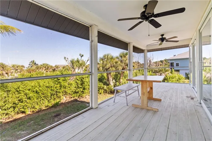 Unfurnished screened balcony featuring dual ceiling fans