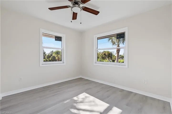 Guest bedroom 2 featuring light wood-style floors and a ceiling fan