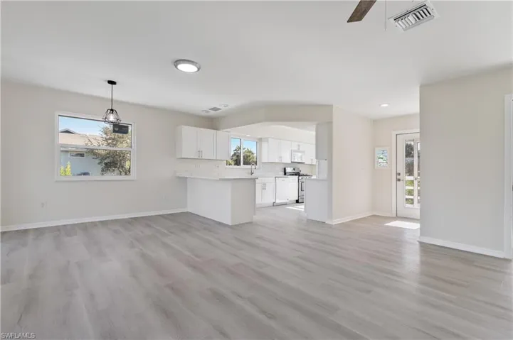 Unfurnished living room with light LVP wood-style flooring and ceiling fan
