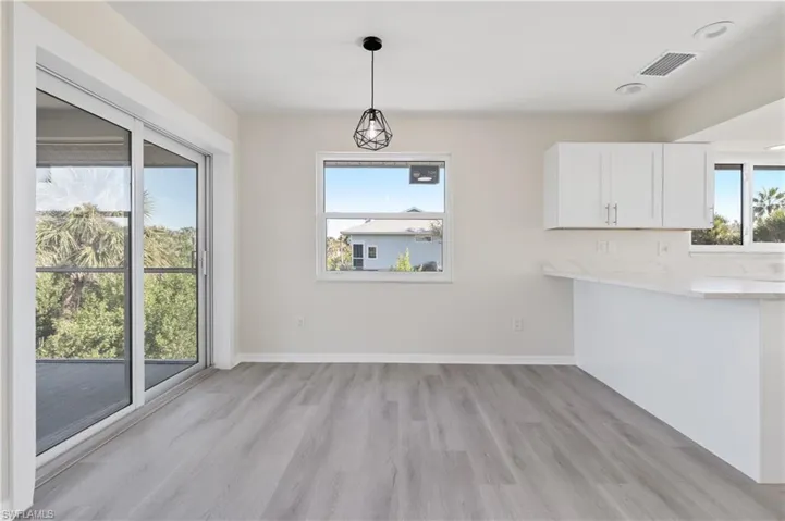 Unfurnished dining area featuring light LVP wood-style floors and baseboards