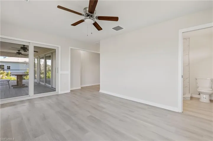 Primary bedroom with slider door access to screened balcony