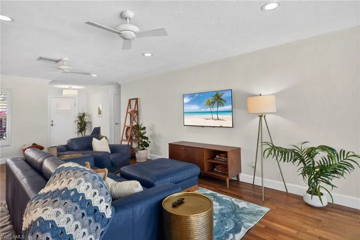 Living area featuring wood finished floors, a ceiling fan, crown molding, recessed lighting, and a textured ceiling