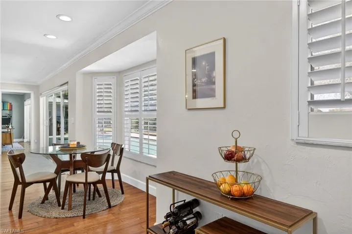 Dining room with hardwood / wood-style floors, ornamental molding, and recessed lighting