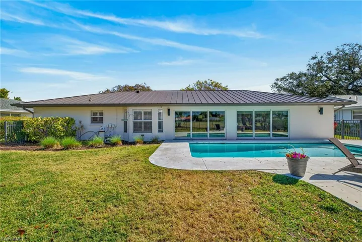 Rear view of house featuring an outdoor pool, a patio, and stucco siding
