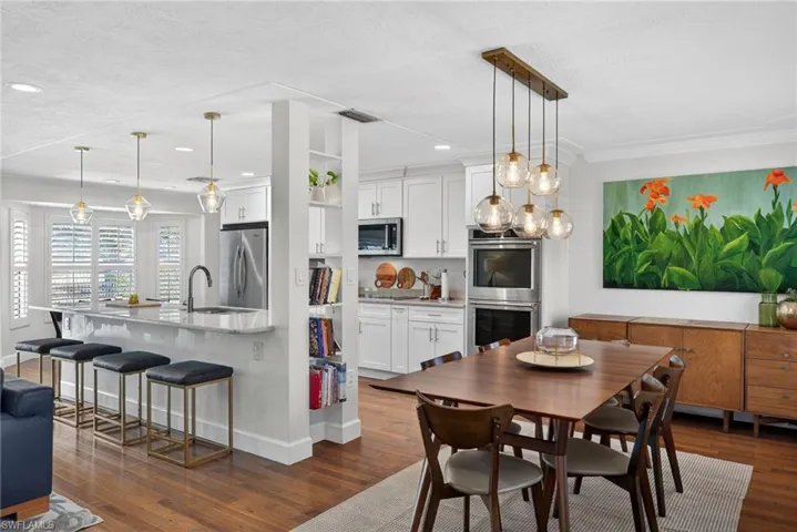 Dining area featuring dark wood-style floors, crown molding, and recessed lighting
