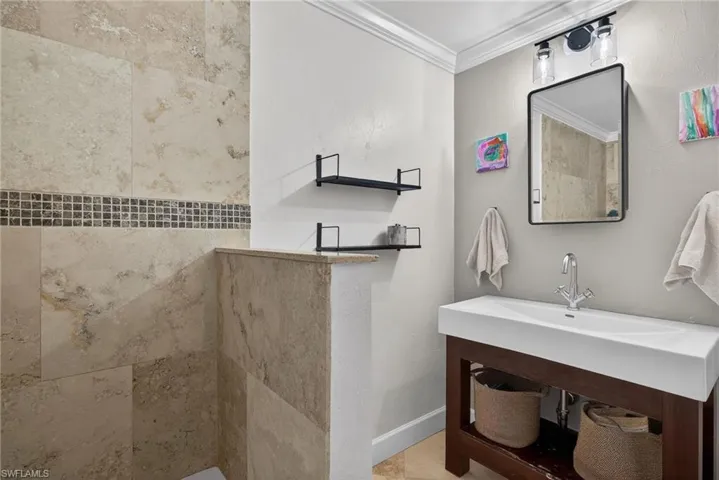 Bathroom with ornamental molding and baseboards