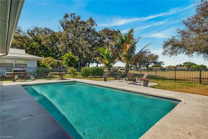 View of swimming pool with patio surround and a fenced backyard