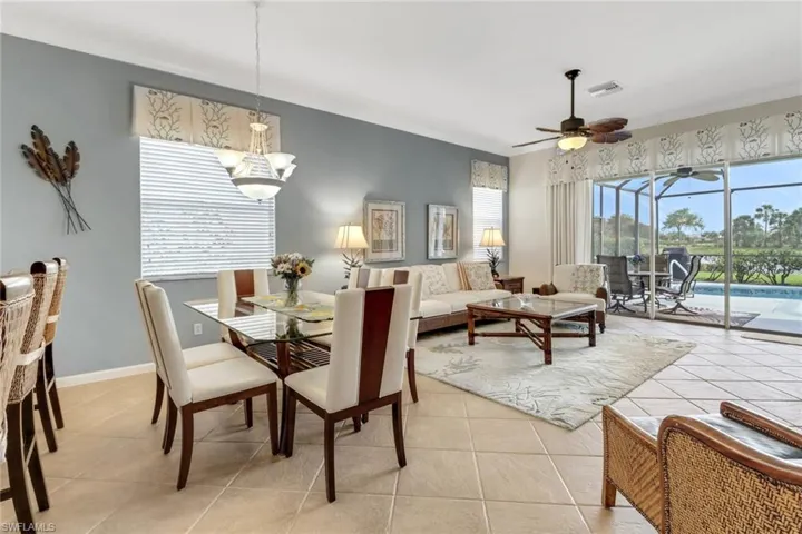 Dining space with light tile patterned flooring, ceiling fan, crown molding, and a sunroom