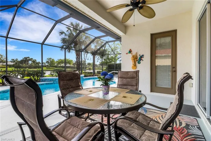 View of patio with glass enclosure, an outdoor pool, a sunroom, ceiling fan, and outdoor dining space