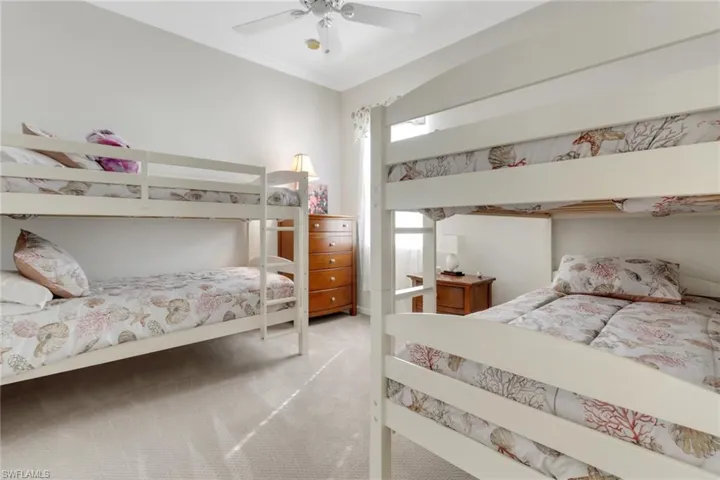 Bedroom with light colored carpet, a ceiling fan, and crown molding