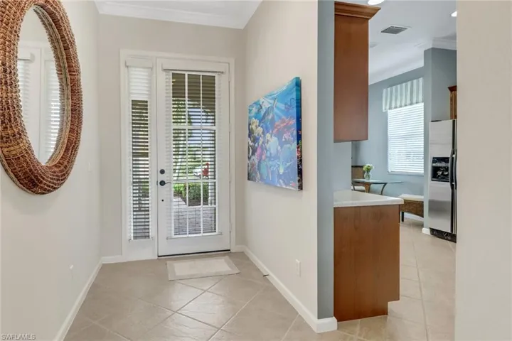 Doorway featuring ornamental molding and tile patterned floors