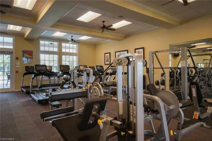 Exercise room featuring ornamental molding, ceiling fan, and beamed ceiling