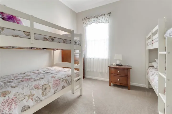 Bedroom with light carpet and crown molding