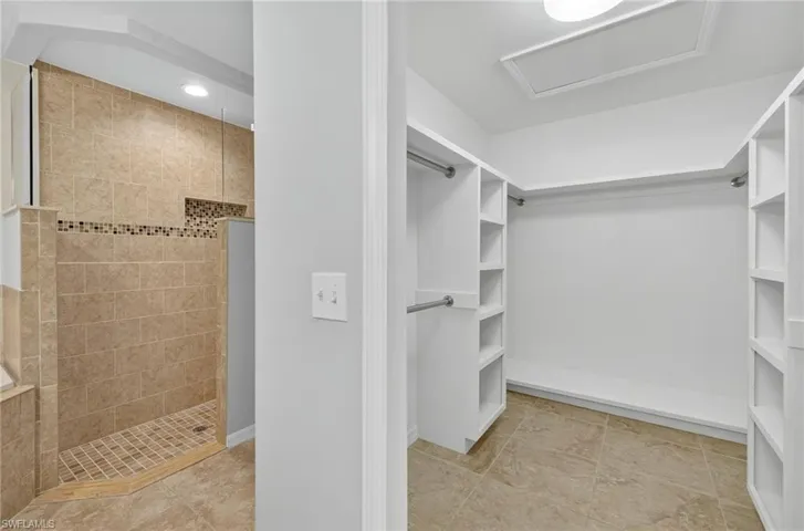 Walk in closet featuring light tile patterned floors and attic access