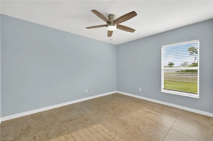 Spare room featuring a ceiling fan and light tile patterned floors