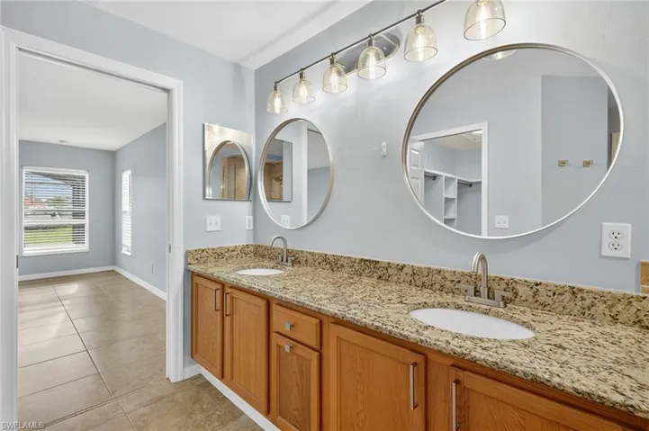 Bathroom featuring double vanity and light tile patterned flooring
