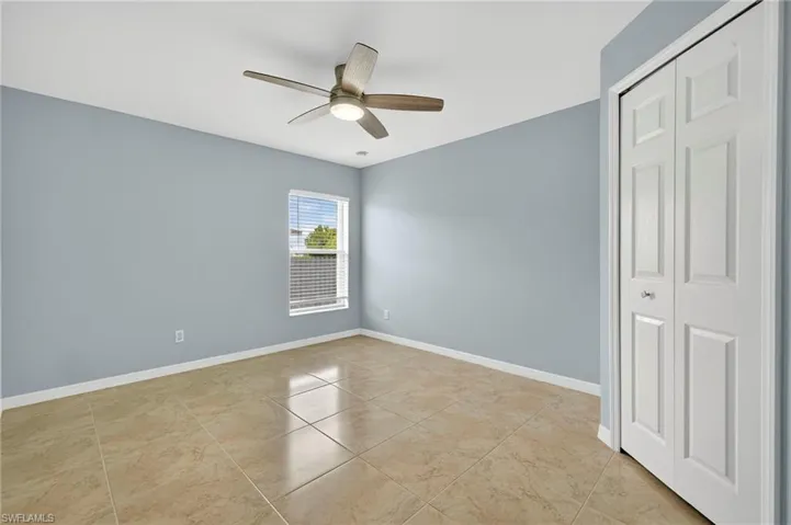 Spare room featuring ceiling fan and light tile patterned floors