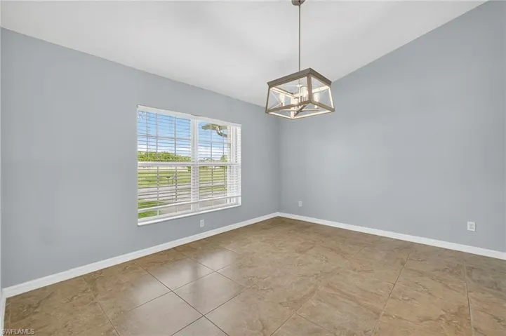 Unfurnished room featuring a chandelier and lofted ceiling