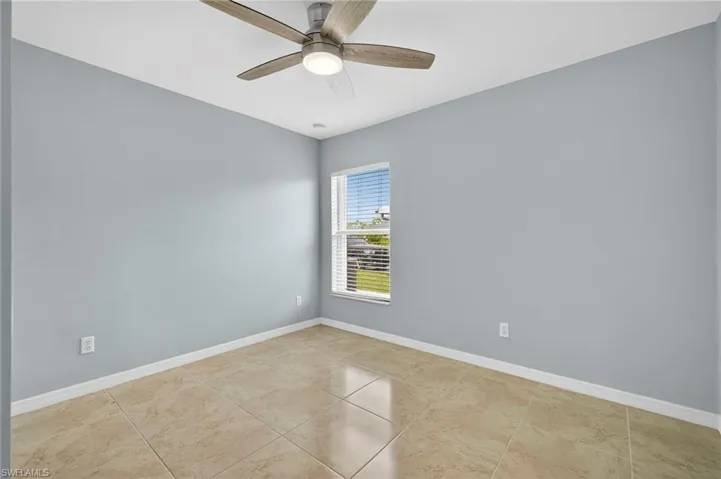Spare room with a ceiling fan and light tile patterned floors