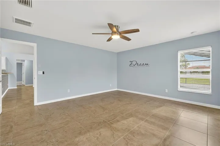 Spare room featuring ceiling fan and light tile patterned floors