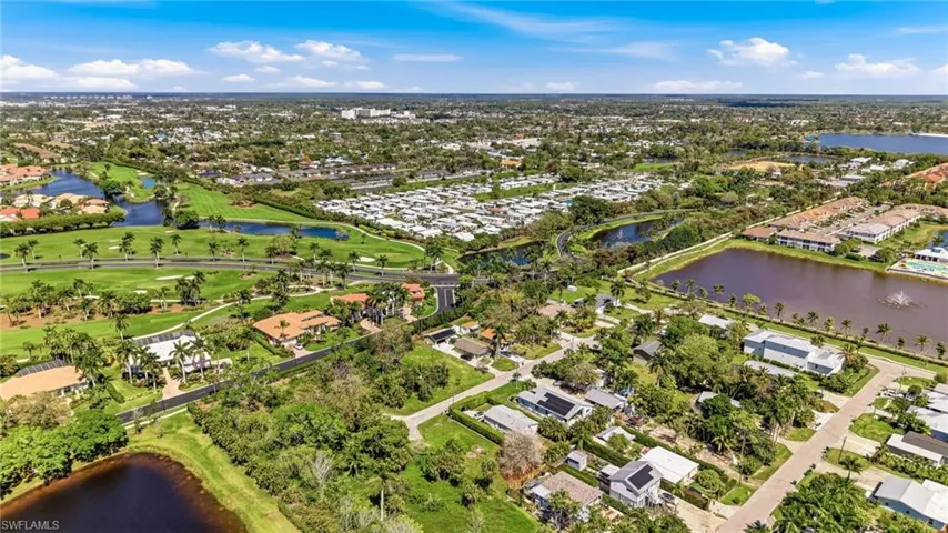 Aerial view of residential area featuring a large body of water and a golf club