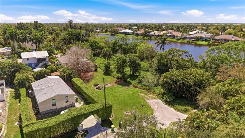 Aerial perspective of suburban area featuring a tree filled landscape and a nearby body of water
