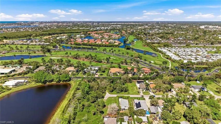 Aerial view of residential area with a nearby body of water and a golf course