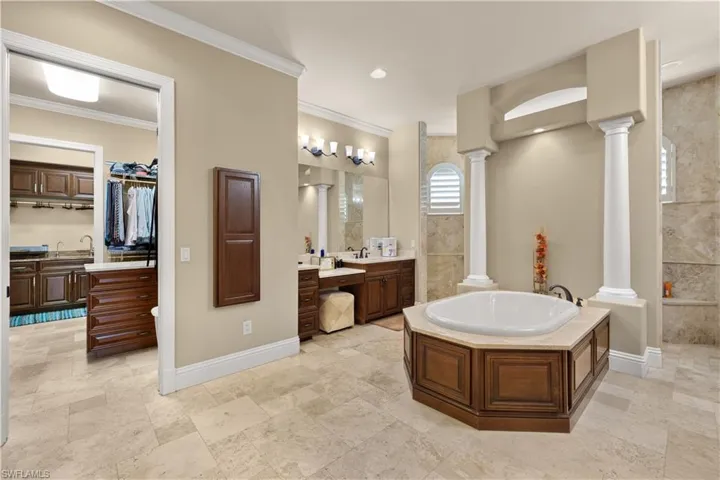 Bathroom featuring a tub to relax in, vanity, and ornamental molding