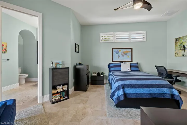 Bedroom featuring ceiling fan and ensuite bathroom