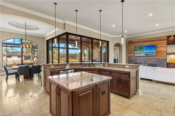 Kitchen with a large island, a healthy amount of sunlight, and pendant lighting