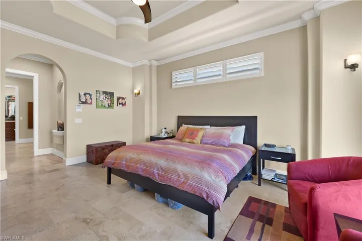 Bedroom featuring a tray ceiling, ceiling fan, and ornamental molding