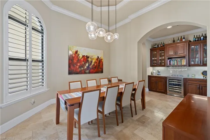 Dining area featuring wine cooler and ornamental molding