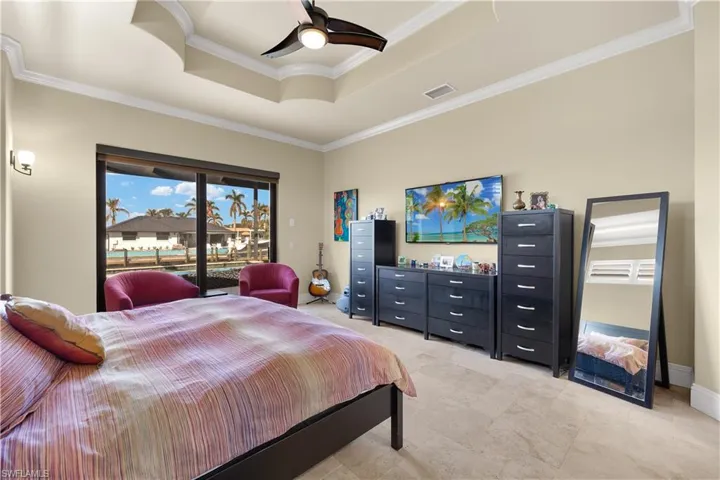 Bedroom with access to outside, ceiling fan, crown molding, and a tray ceiling