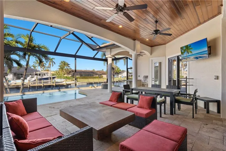 View of patio / terrace featuring glass enclosure, a water view, ceiling fan, and an outdoor hangout area