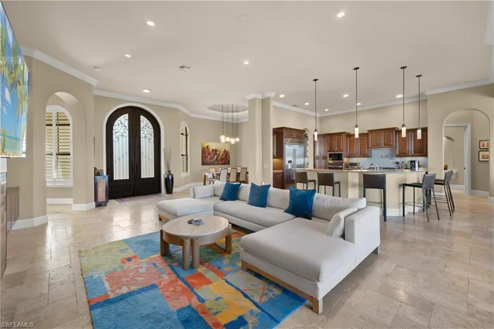 Living room featuring a chandelier, crown molding, and french doors
