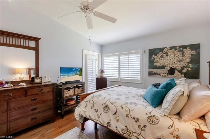 Bedroom with light wood finished floors, a ceiling fan, and vaulted ceiling