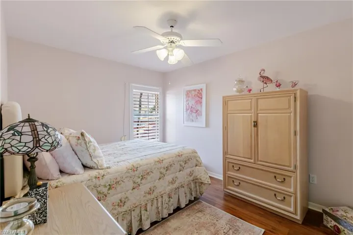 Bedroom with dark wood-style floors and ceiling fan