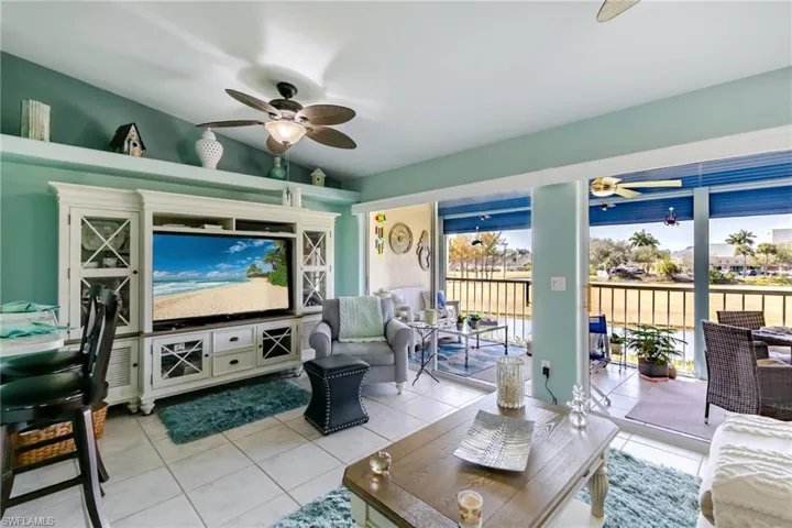 Living area with light tile patterned floors, a ceiling fan, and vaulted ceiling