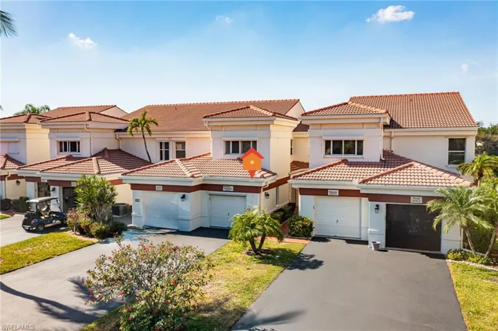 Carriage Home featuring stucco siding, asphalt driveway, and a tile roof