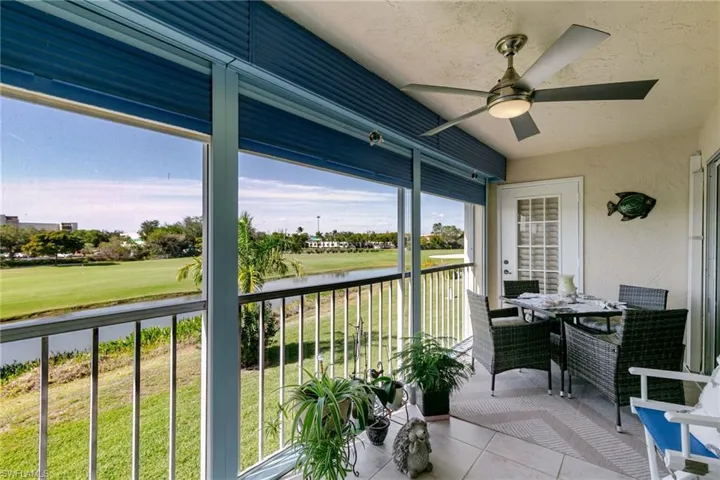 Lanai with outdoor dining area, a water view, ceiling fan, and golf course view
