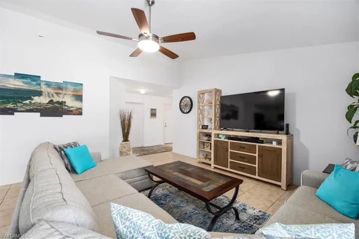 Living area with a ceiling fan and light tile patterned floors