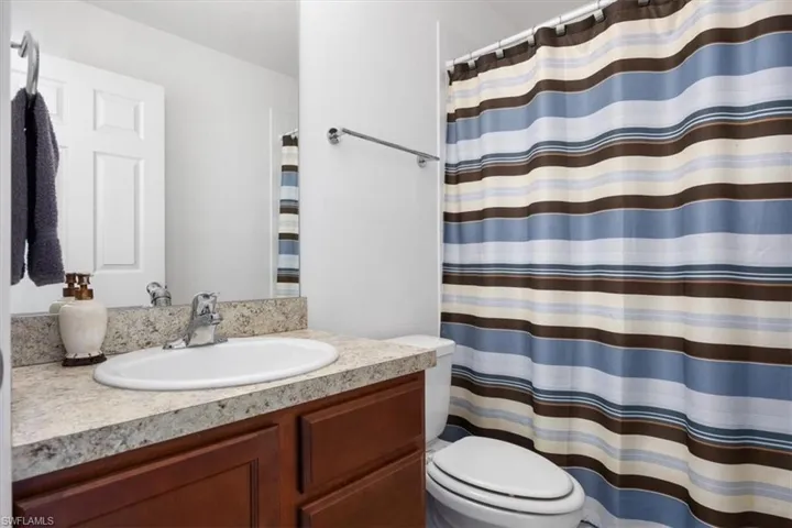 Full bathroom featuring curtained shower and vanity