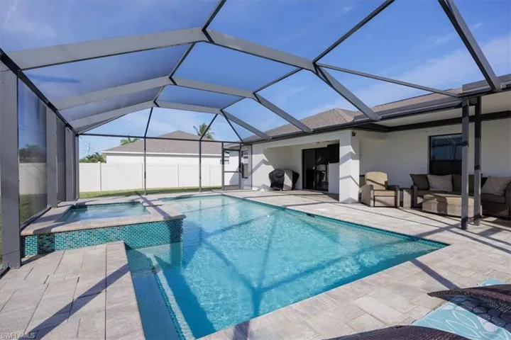 View of swimming pool with a sunroom, a pool with connected hot tub, a lanai, and a patio