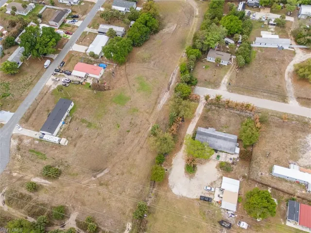 Aerial view of property and surrounding area featuring nearby suburban area