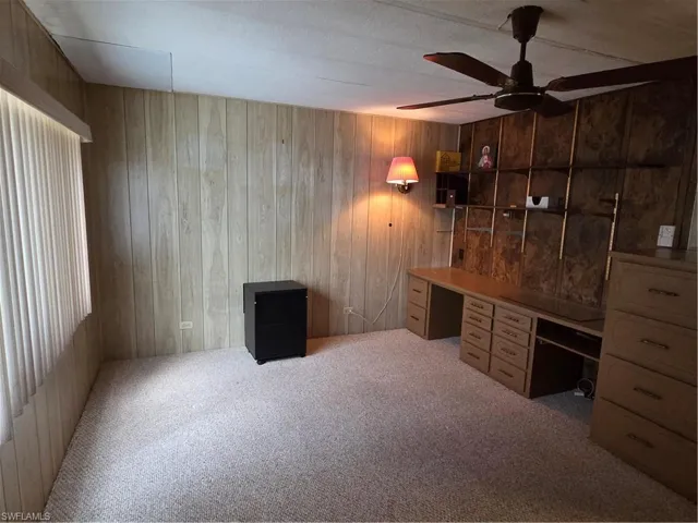 Bedroom with neutral carpet and ceiling fan.