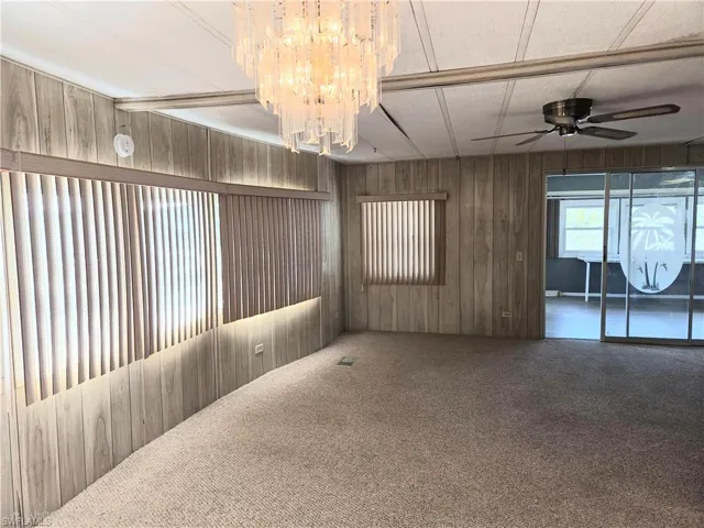 Living room with ceiling fan and neutral carpet.