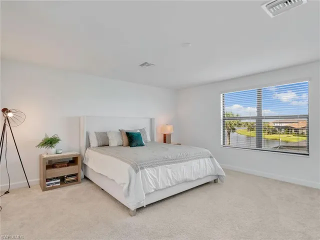 Bedroom with light colored carpet and baseboards