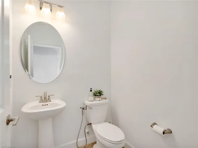 Half bathroom featuring toilet and baseboards