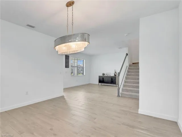 Unfurnished dining area with stairs and light wood-type flooring