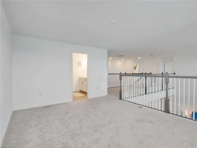 Spare room with light colored carpet and baseboards